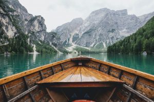 world travel on a budget brown wooden boat moving towards the mountain